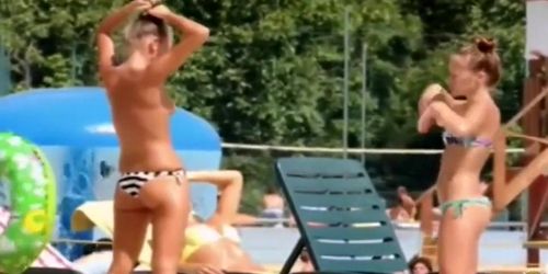 Topless petite girl looks sexy at the water park