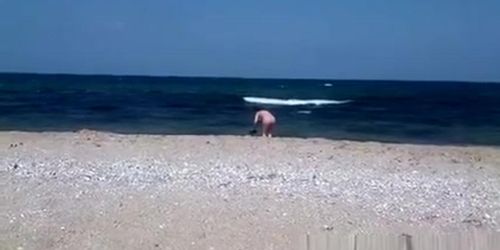 Pregnant nudist woman at beach