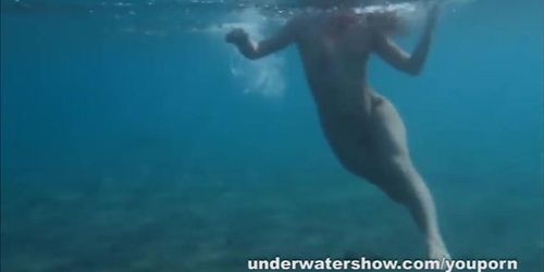 Julia is swimming underwater nude in the sea