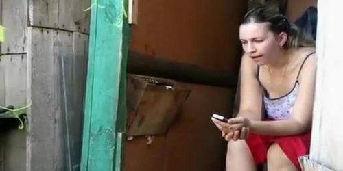 Woman takes a pee in old wood toilet