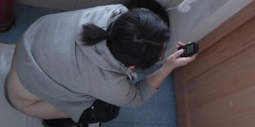 Asian girl and her cell phone in this toilet spy cam video