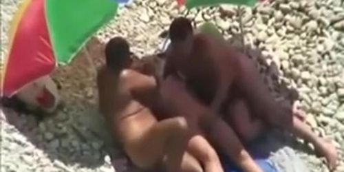 Threesome sex fun on public beach caught on voyeur cam