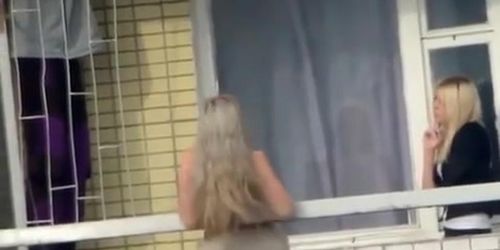 Voyeur films topless chick in the balcony