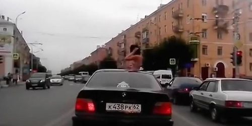 Topless girl riding in a BMW while in Russia