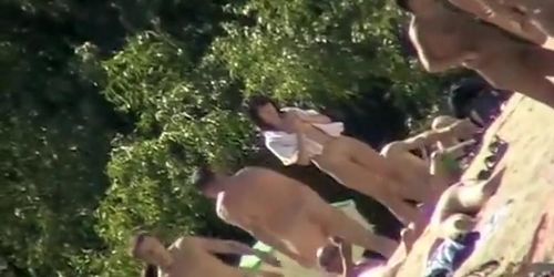 Young nudists take off their clothes to soak up some sun on