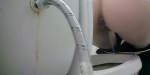 Woman takes a piss in toilet