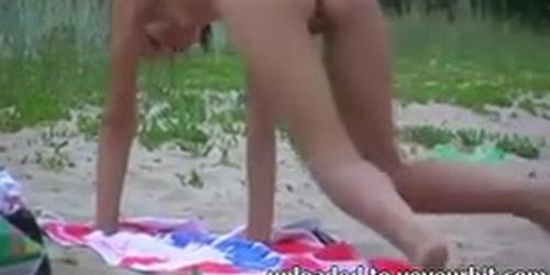 Girl showing her pussy, reading a book at a public beach