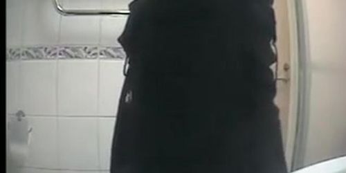 Girl in black clothes pees in toilet