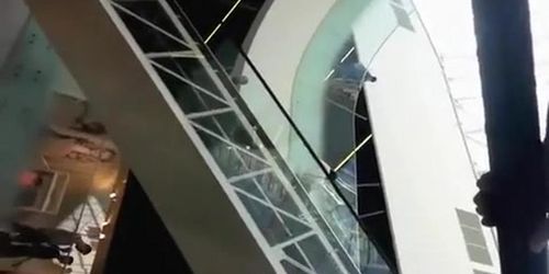 Upskirted in the shopping mall rolling stairs
