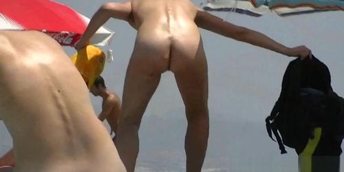 Nudist video at the beach has shy girl playing in the water