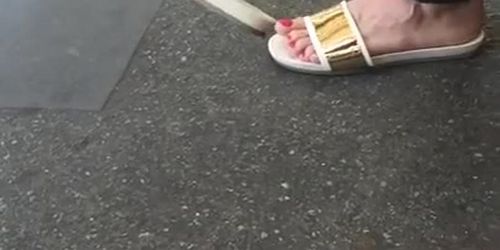 Sexy feet at London tube station, red toes dangling feet