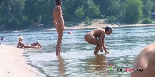 Playful blond nudist teen caught on camera naked at the beach