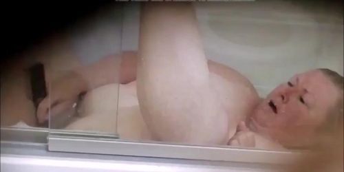 See 55 year old fat Grandma C.K. masturbate in the bathtub with a hair brush.