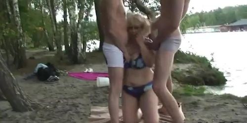 Two dudes bang old bitch from both ends outdoors