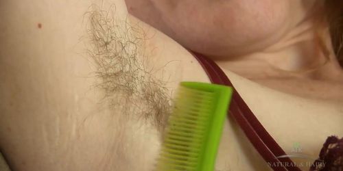 Redhead with a huge bush and hairy pits combs her body hair and spreads her big gaping pussy.