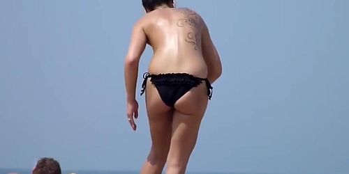 Classless chick with big boobs and tattoo's on a beach