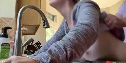 mature bent over the sink in the kitchen