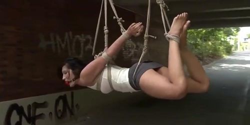 Gagged slut suspended from a bridge
