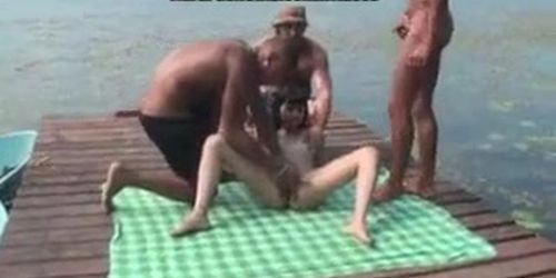 horny slutty nympho girl gives a trio of horny guys a blowjob on the docks while friend films her on camera