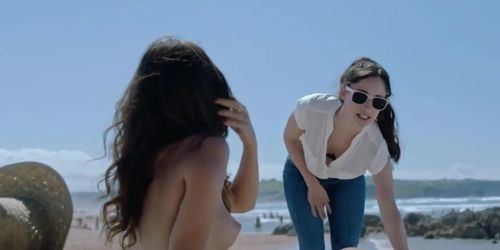 Latina taking topless pictures of her friend at the beach