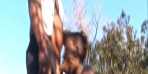 Busty African chick enjoys slurping cock outdoors