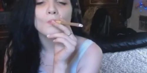 Sexy young brunette girl smoking tipped cigar