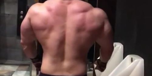 hot bodybuilder hunk is flexing in toilet