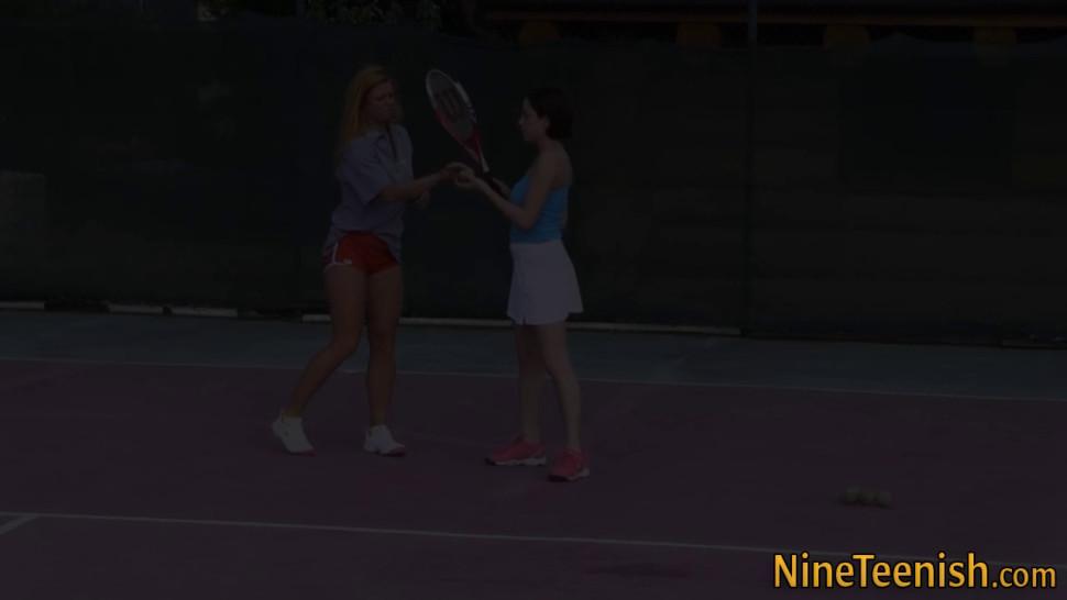 Lesbian teens on outdoor tennis court