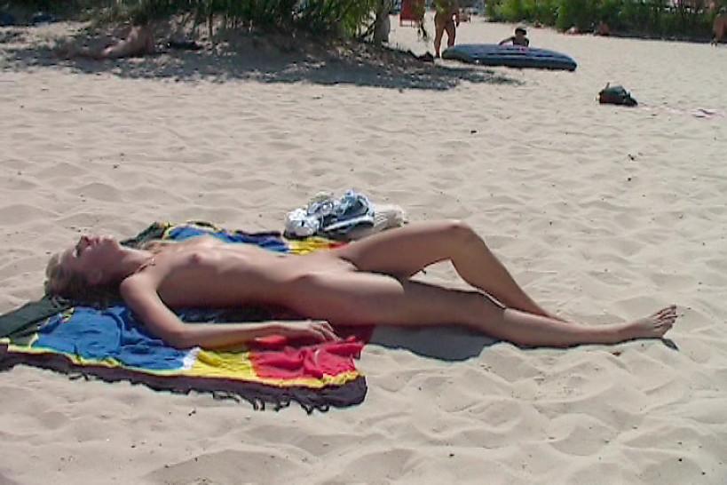NUDIST VIDEO - Watch a naked chick at the beach tan her hot body - video 1