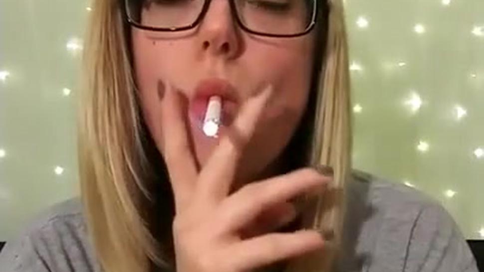 Beautiful young blonde girl smoking corks in glasses