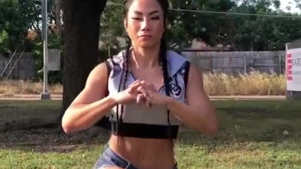 Fitness girl Tina Nguyen flexing muscle and squating