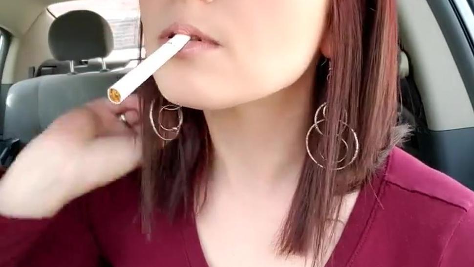 Sexy young redhead girl smoking in car