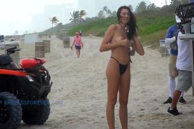 Buying a snack at the beach topless