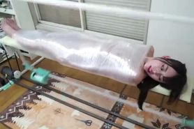 Girl wrapped by cling film machine