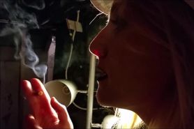 Sexy young blonde taking deep cigarette drags