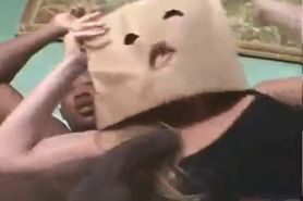 Bitch with paper bag on face blows 2 black rods& gets fucked