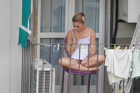 Candid blonde showing her feet on the fence in a way that reveals upskirt