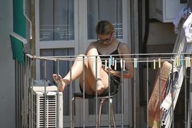 Candid blonde girl showing her feet on the balcony