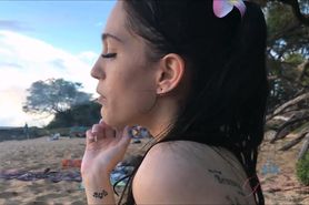Beautiful brunette girl smoking & playing on beach