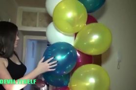 Brunette girl popping balloons