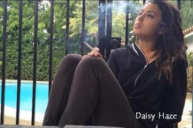 Topless girl takes a smoke break by the pool