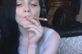 Sexy young brunette girl smoking tipped cigar