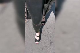 Girl wearing latex leggings and high heels in public