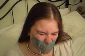 Tied girl can't work duct tape gag loose