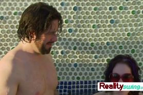 Bisexual swingers kissing during pool party