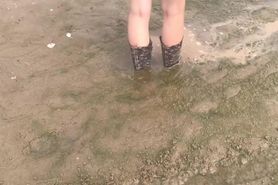 Alice in heeled rubber boots in a stream