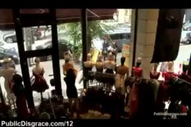 Bare bound blonde pose in shop window while pedestrians watches