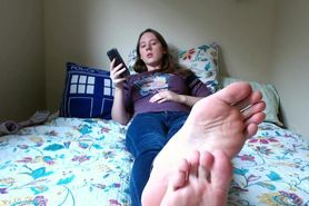 Girl shows off her soles in bed