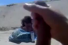 Lady takes photos of guy flashing on the beach
