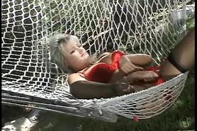 Busty blonde in outdoor hammock fondles her tits and plays with her pussy